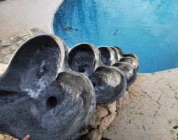 Photo en surplomb d'une cascade de 5 Vasques Vives en pierre de basalte sur le bassin des otaries du zoo d'African Safari.