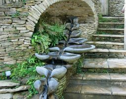 La fontaine Symphonie, avec toutes les Vasques Vives, installée sous une arche de pierres accompagnant la descente d'un escalier.